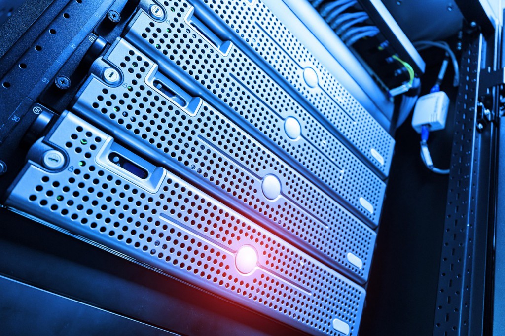 Server technician checking hosting issues on a laptop with alert icons on screen.